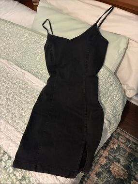 Stretchy black faded denim mini spaghetti strap dress with leg slit.